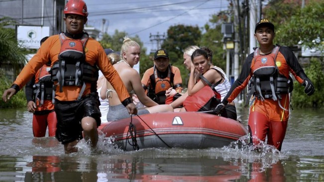 Petugas BPBD mengevakuasi korban banjir di Bali. [X]